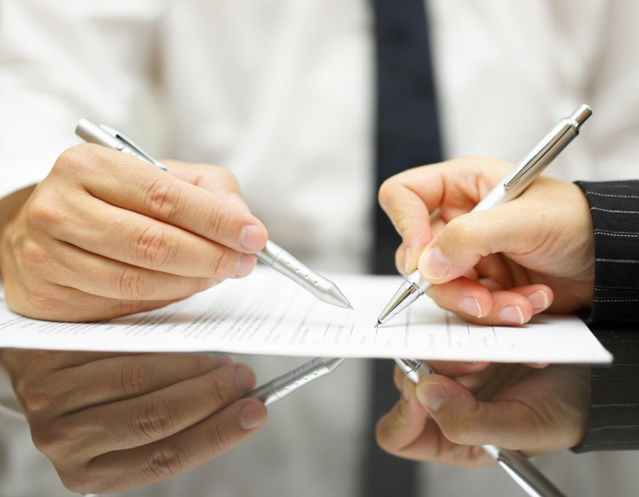 Business man is pointing woman where to sign document